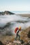 Woman traveler hiking with backpack above clouds travel outdoor climbing adventure vacation