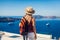 Woman traveler looking at Caldera from Fira or Thera, Santorini island, Greece. Tourism, traveling, vacation concept