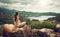 Woman traveler looks at the edge of the cliff on the sea bay of