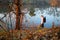 Woman traveler near forest river in autumn