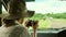 woman traveler and photographer standing in safari looking at wildlife animals