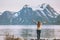 Woman traveler raised hands enjoying Norway mountains view