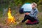 Woman traveler resting by the fire on the background of a tent o