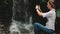 Woman traveler stand near waterfall at rainforest