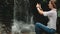 Woman traveler stand near waterfall at rainforest