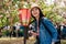 Woman traveler standing near the japanese red lantern and surrounding by the pink beautiful sakura flower. young lady traveler