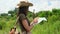 A woman traveler stands near a giraffe and looks at a map among the savannah