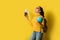 .Woman traveler with suitcase, holding ball globe in the hand with passport and ticket on Yellow background. Portrait of smiling