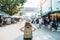 woman traveler visiting in Bangkok, Tourist with backpack and hat sightseeing in Chatuchak Weekend Market, landmark and popular