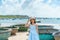 Woman traveler visiting at My Khe beach and sightseeing basket finishing boats. Tourist with blue dress and hat traveling in Da