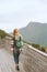 Woman traveling with backpack walking on wooden bridge in Norway