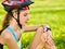 Woman traveling bicycle in summer park. Girl watch smart watch.