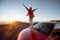 Woman traveling by car on the rocky terrain above the clouds