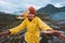 Woman traveling in Norway mountains windy weather outdoor vacations adventure lifestyle emotional girl wearing yellow raincoat