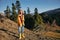 Woman traveling to the mountains in the fall on a nature hike smile and happiness in a yellow cape with red hair full