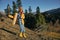 Woman traveling to the mountains in the fall on a nature hike smile and happiness in a yellow cape with red hair full