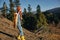 Woman traveling to the mountains in the fall on a nature hike smile and happiness in a yellow cape with red hair full