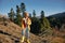 Woman traveling to the mountains in the fall on a nature hike smile and happiness in a yellow cape with red hair full