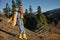 Woman traveling to the mountains in the fall on a nature hike smile and happiness in a yellow cape with red hair full