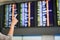 Woman traveller checking flight a departures board at the airport terminal.