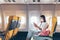 Woman traveller passenger sitting at airplane seat using smartphone onboard in new normal covid 19 pandemic