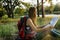 Woman traveller sitting in park outdoor