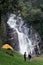 woman traveller walk togather Tent and camping with Mae Tia waterfall and mountain background at inthanon national park in Chiang