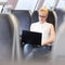 Woman travelling by train working on laptop.