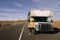 A woman travels by motorhome through Monument Valley in the USA desert and checks her mobile phone parked