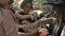 Woman treats sweets to a group of children in black fancy dress with scary makeup on their faces. Halloween traditions.