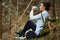 Woman trekker drinking water in the forest