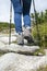 Woman with trekking boots and sticks on the rocky trail