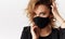 Woman in trendy fashionable outfit during quarantine of coronavirus outbreak. Model dressed stylish black protective face mask