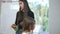 A woman trichologist conducts a seminar standing near a white presentation board with a girl patient who is sitting on a