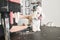 Woman trimming a white happy maltipoo standing at the table