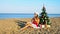 Woman on a tropical beach with a Christmas tree