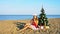 Woman on a tropical beach with a Christmas tree