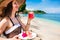 Woman at tropical beach eating fruit for breakfast