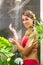 Woman in tropical garden having shower