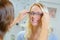 Woman trying on glasses in optical store