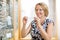 Woman Trying On Glasses At Optician Store