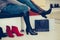 Woman  trying on new pair of winter boots with high heels while sitting at a fashion store