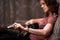 woman tuning guitar at home on the couch