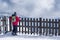 Woman turned away near a fence