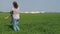 A woman is turning a child. Mom and daughter are playing in the open air. Girl with a child on a meadow in the background of the c