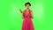 Woman with TV remote in her hand, switching on TV. Green screen