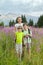 A woman and two boys stand on field of fireweed