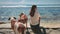 Woman with two brown dogs relax sitting sea beach