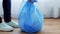 Woman tying bag with garbage at home