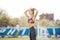 Woman tying hair in ponytail getting ready for exercising. Beautiful young sporty woman attaching her long hair at stadium. Smilin